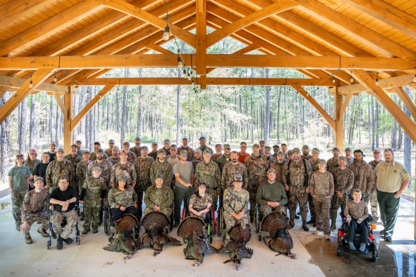 Fifteen hunters and their escorts gathered at the University of Georgia Savannah River Ecology Laboratory Conference Center for a group photo following the first hunt of the event.