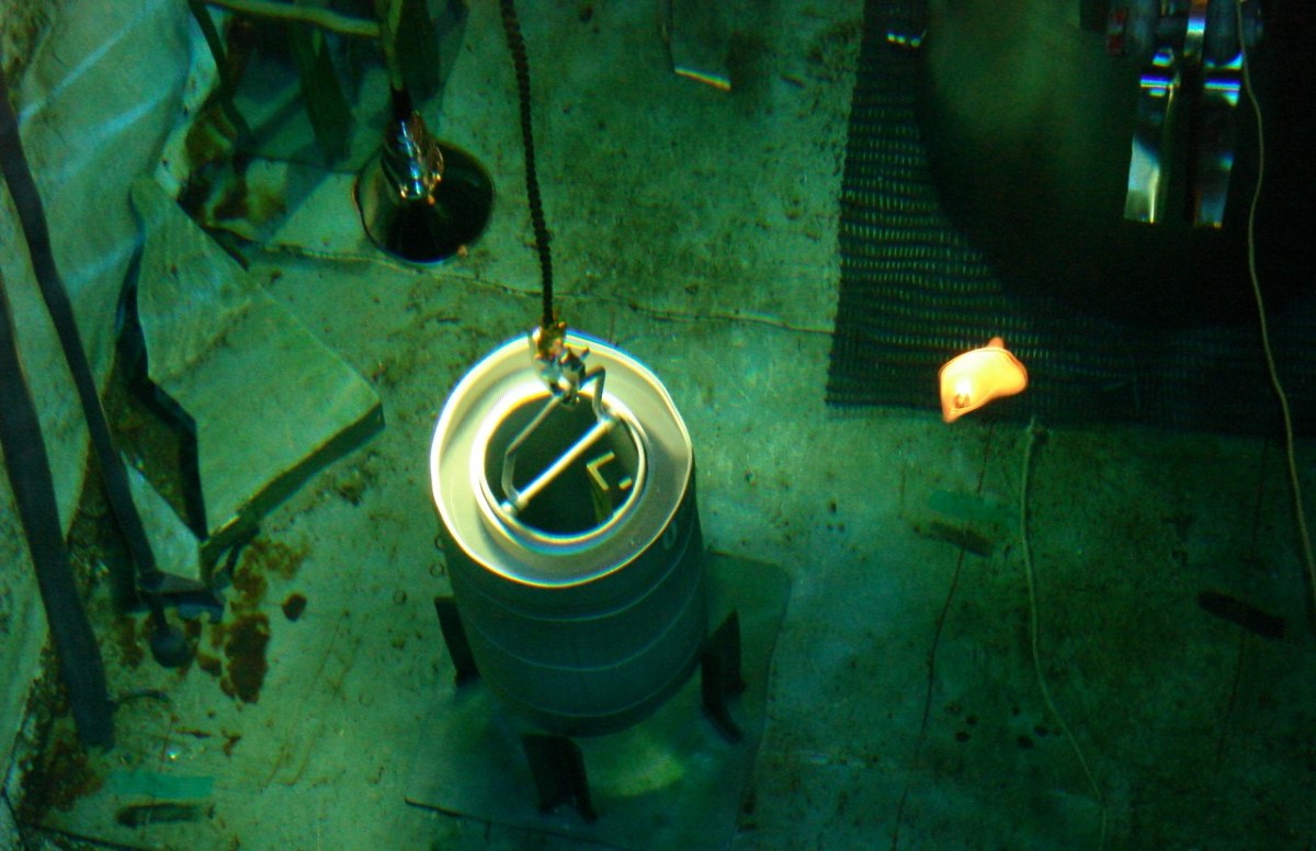 A HFIR Core being lifted in the underwater assembly basin at SRS.