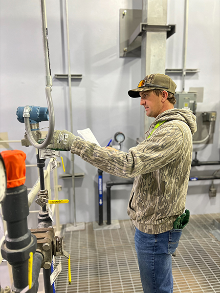 Apprenticeship Program participant takes a reading from a piece of equipment.