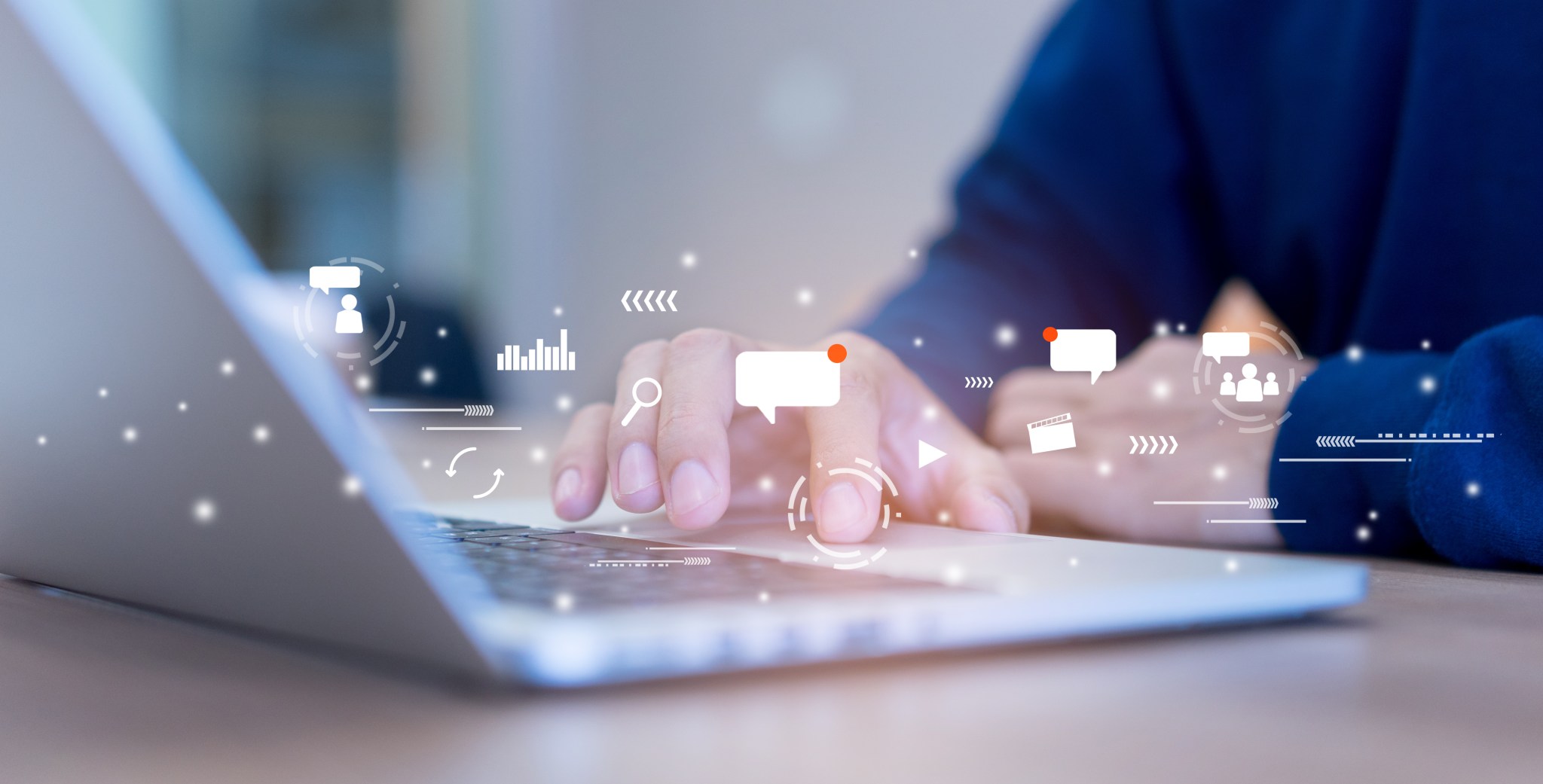 Image of person using laptop with social media icons superimposed above the keyboard.