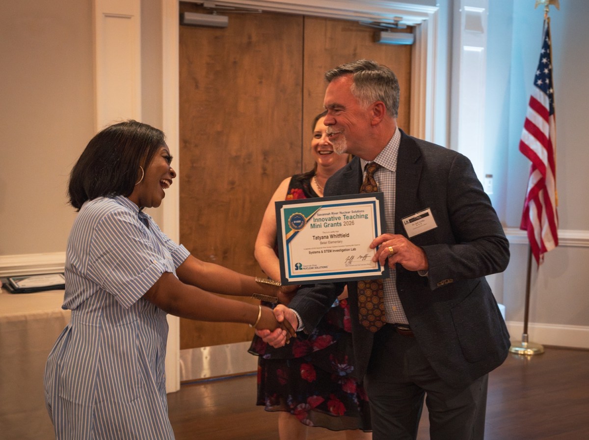 Jeff Griffin, SRNS President and Chief Executive Officer awards a ,000 Mini Grant to Belair Elementary Educator Tatyana Whitfield for a systems and STEM investigation lab experiment. Also pictured: Lindsey MonBarren, Manager, SRNS Corporate Communications.